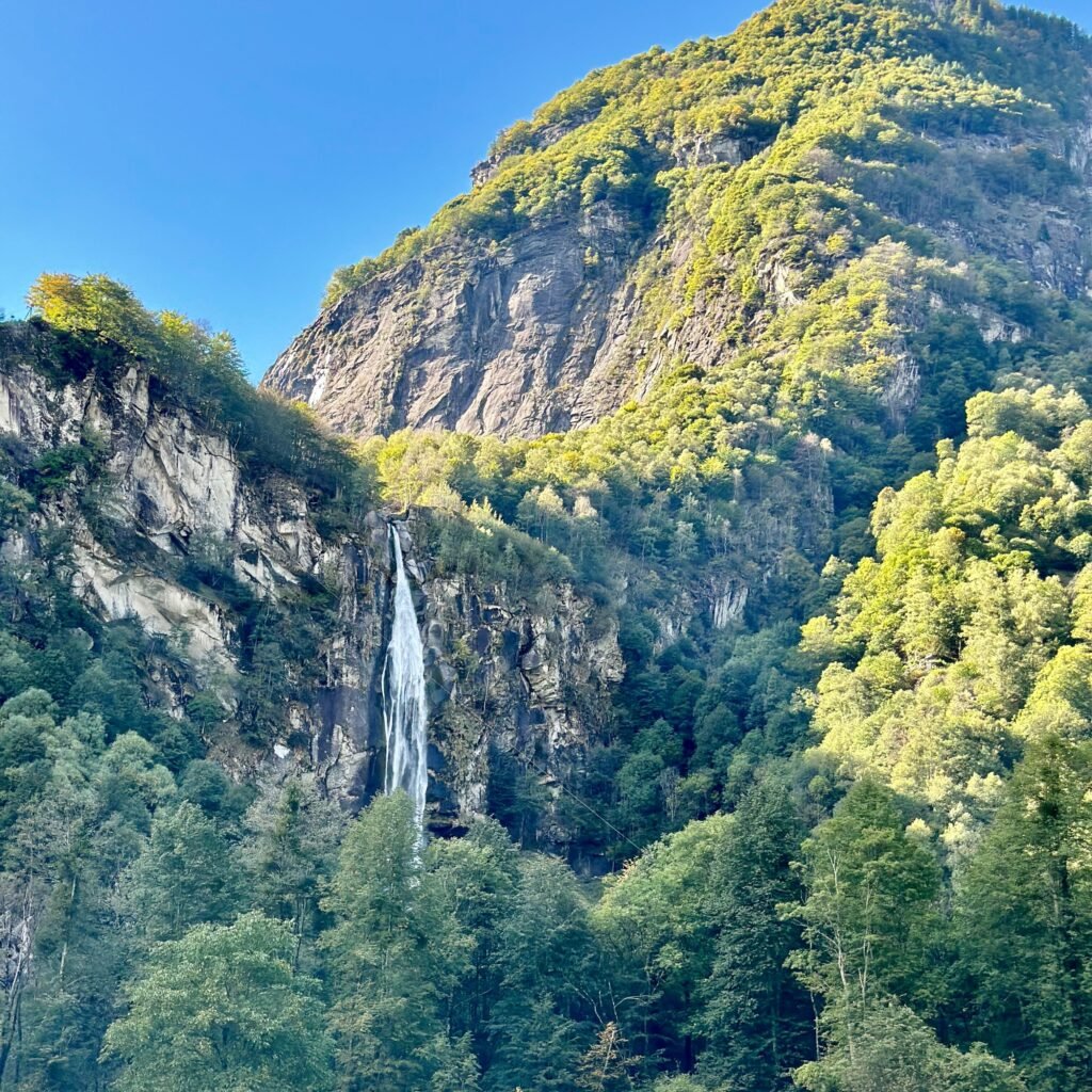 Foroglio Waterfall in Valle Maggia, Ticino, Switzerland, cascading down a rocky mountain surrounded by lush alpine scenery